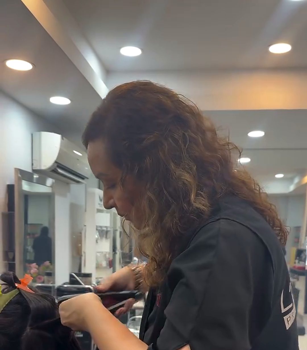 A Vibes stylist blow-drying a client's hair in the salon